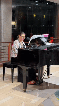 Woman plays grand piano in Bangkok lobby