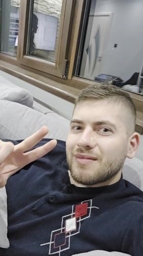 Man resting on couch points to chest in Bulgaria