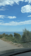Vehicles travel coastal road in Višnjevo, Montenegro
