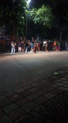 Late-night street gathering in Bogor with flares and motorcycles
