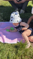 Infant plays on a blanket in the grass, Votkinsk summer
