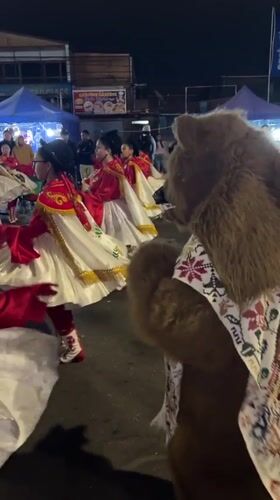 Nighttime street festival parade with elaborate costumed dancers in Arica