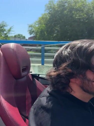 Convertible drives through The Hague city center on sunny afternoon