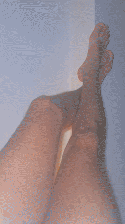 Person rests with feet up against wall in Thailand