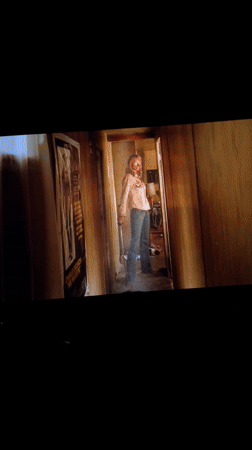 Movie screening captured in Málaga theater showing black-and-white film