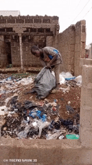 Youth collects trash among waste piles in Rigasa