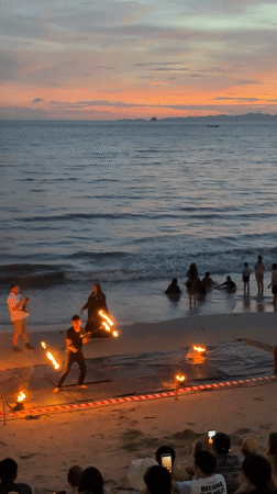 Fire dancing performance on Ban Ao Nang beach at sunset