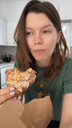 Woman enjoys almond croissant breakfast in Limassol, Cyprus