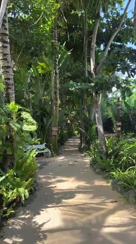 Woman walks through tropical resort pathways in Blahbatuh, Indonesia