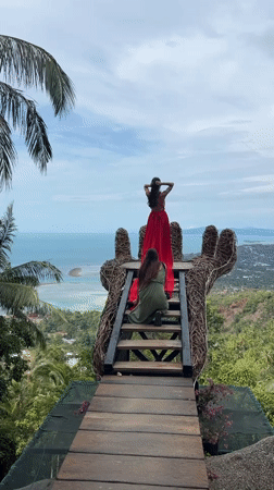 Women pose on hand-shaped viewing platform in Ko Samui