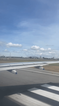Passenger films wing view during aircraft movement in Thailand