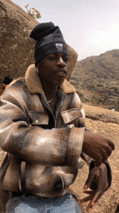 Young man sits on rock along Rukuba Road Nigeria