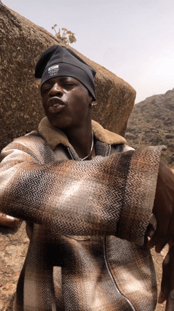 Young man sits on rock along Rukuba Road Nigeria