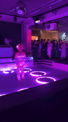 Costumed performer dances in illuminated pool at Berlin venue