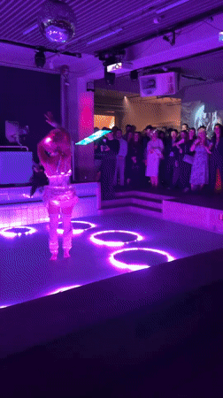 Costumed performer dances in illuminated pool at Berlin venue
