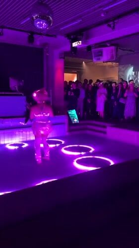 Costumed performer dances in illuminated pool at Berlin venue