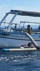 Outrigger boats carry passengers in calm waters near Seririt
