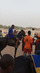 Horseback riders gather in sandy field in Giginyu, Nigeria