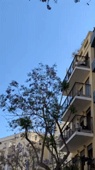 Worker repairs building exterior using boom lift in Tel Aviv