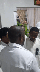Indoor gathering with people in white robes and casual clothing