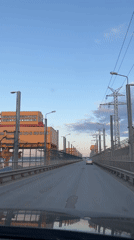 Vehicle crosses bridge over textured river in Chaikovsky, Russia