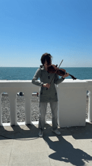 Street musician plays violin on sunny Sochi waterfront