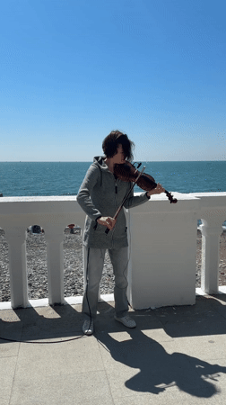 Street musician plays violin on sunny Sochi waterfront