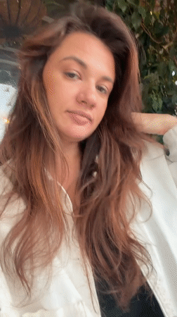 Woman poses for camera at Glifada cafe while drinks served