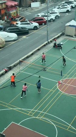 Four players enjoy late night badminton in Baiyun District