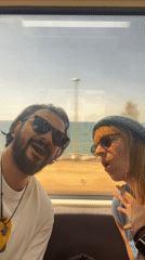 Passengers sing on train passing beachfront in El Masnou