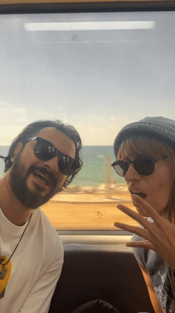 Passengers sing on train passing beachfront in El Masnou