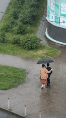 Pedestrians share umbrella during heavy afternoon downpour downtown