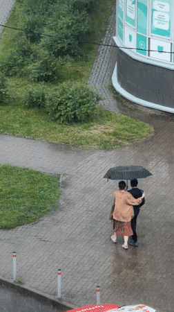 Pedestrians share umbrella during heavy afternoon downpour downtown