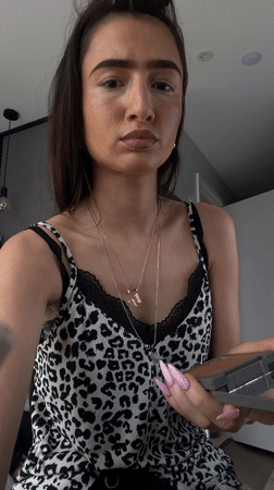 Woman applies makeup in London bedroom Saturday afternoon