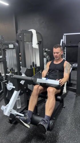 Gym users exercise on leg equipment in Choeng Mon