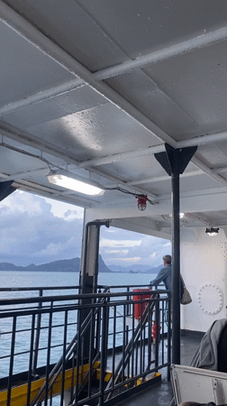 Passenger gazes at islands from ship near Thailand