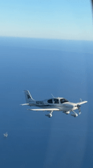 Single-engine plane cruising over the California coast