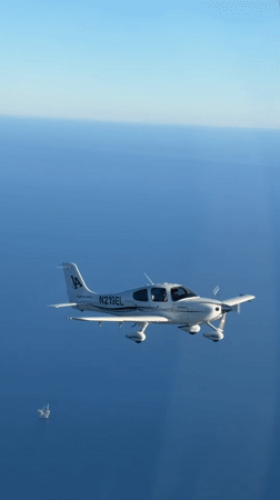 Single-engine plane cruising over the California coast