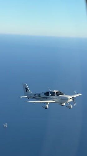 Single-engine plane cruising over the California coast