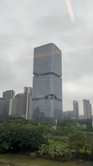 Train passenger films distinctive stacked skyscraper in Panyu District