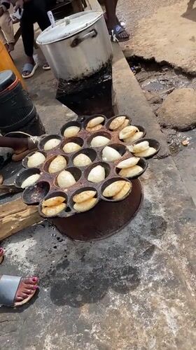 Street food vendors cook pancake snacks in Bukuru Nigeria