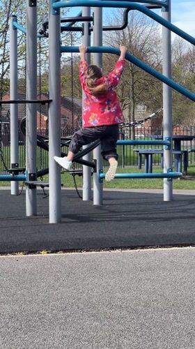 Children play on playground equipment in Macclesfield
