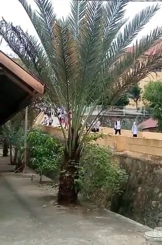 Students on a walkway near Lhokseumawe streets, morning routine