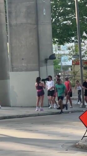 Athletic group gathers under Vancouver bridge with megaphone leader