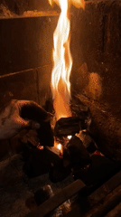 Person tends fireplace fire in Buenos Aires home