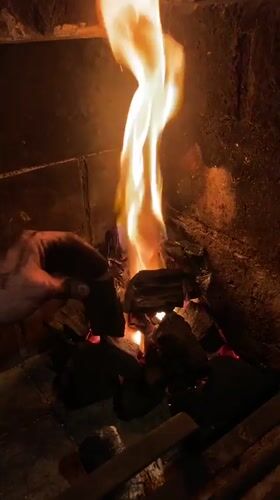 Person tends fireplace fire in Buenos Aires home