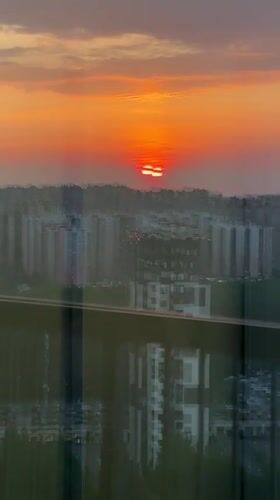Dramatic orange sunset captured over Kudrovo city skyline