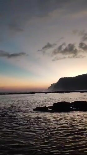 Dawn at a rocky Kuta Selatan beach, waves, crabs, and coastline