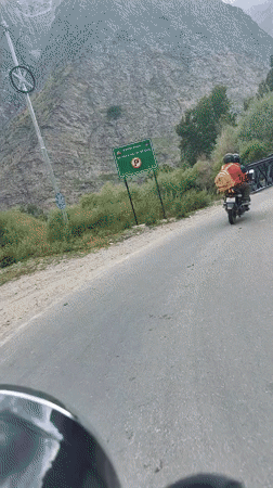 Rider in orange jacket spotted ahead on a Karing road