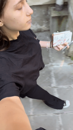 Woman walks with wallet and pen in Sofia morning